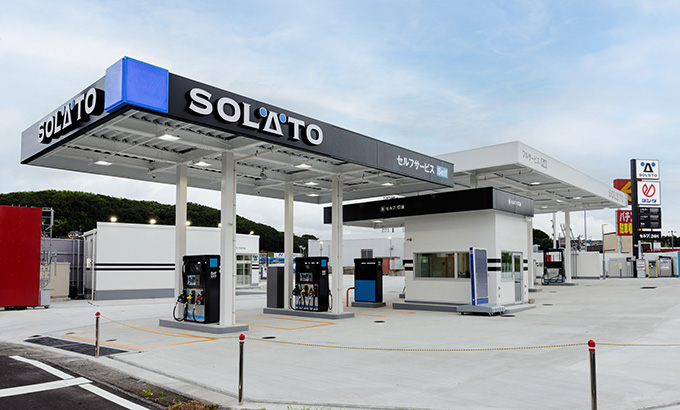 「セルフサービス」の表示があるSOLATOの給油キャノピーと計量機。奥にはフルサービスエリアとサインポール